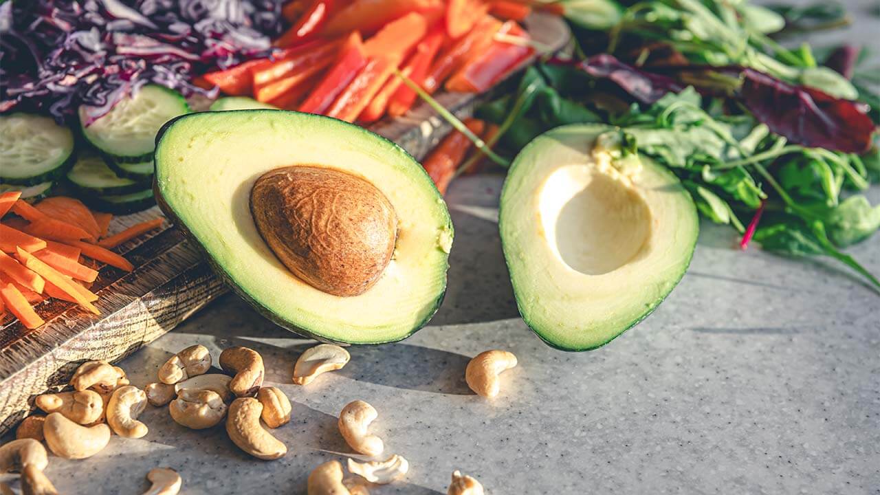 Pestrá paleta potravín – mandle, avokádo a čerstvá zelenina ako zdroje vitamínu E