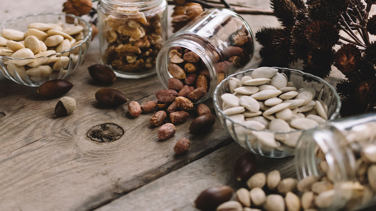 Ako najrýchlejšie doplniť horčík? 6 Rôzne druhy orieškov a semien na drevenom stole.